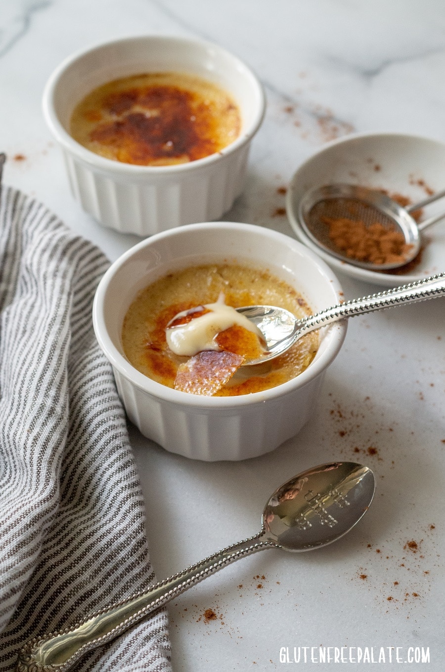 Chai Creme Brulee in a white ramekin with a spoon taking a bite out