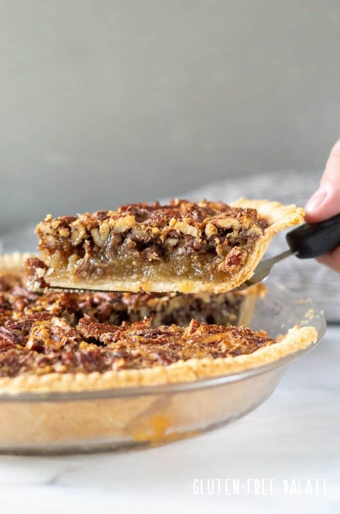 a slice of gluten free pecan pie on a pie server