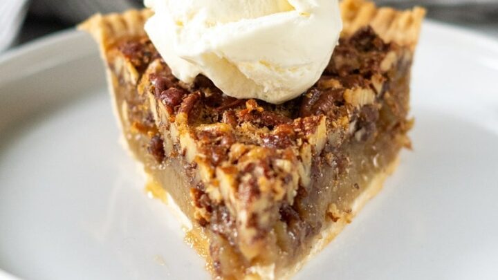 a slice of gluten-free pecan pie topped with a scoop of vanilla ice cream