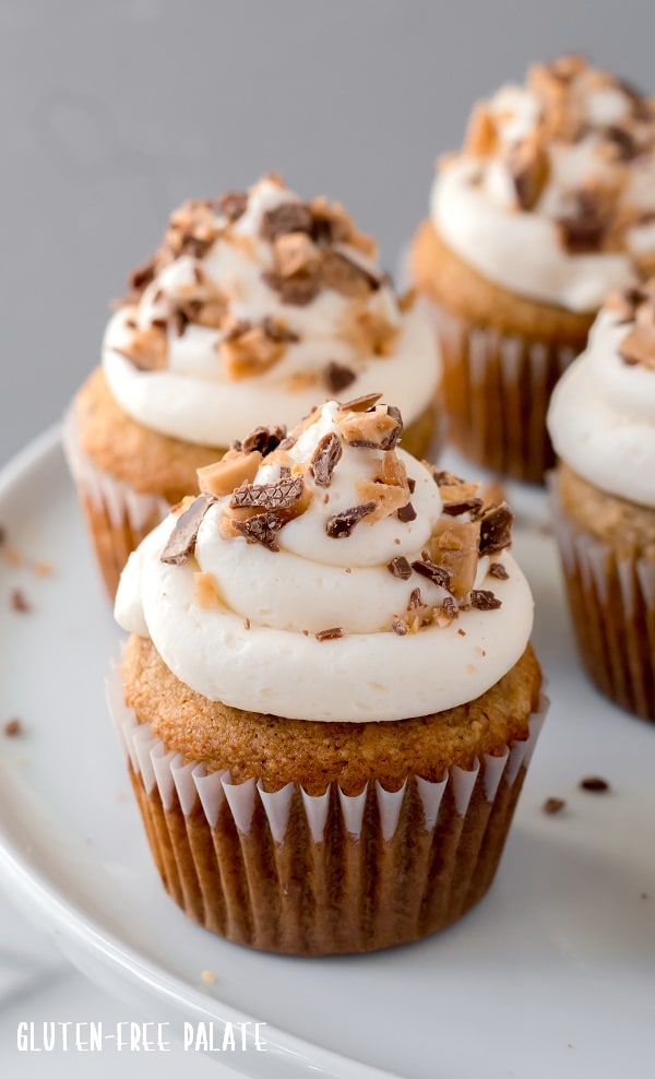 grain-free banana toffee cupcakes with white frosting and toffee on top