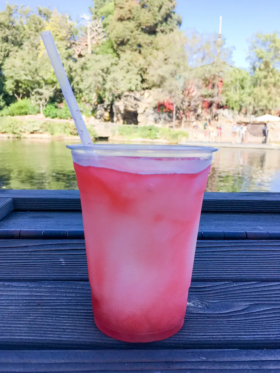 a close up of a pink slushie with a straw