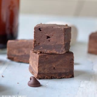 a close up of two pieces of fudge stacked with a chocolate chip in front