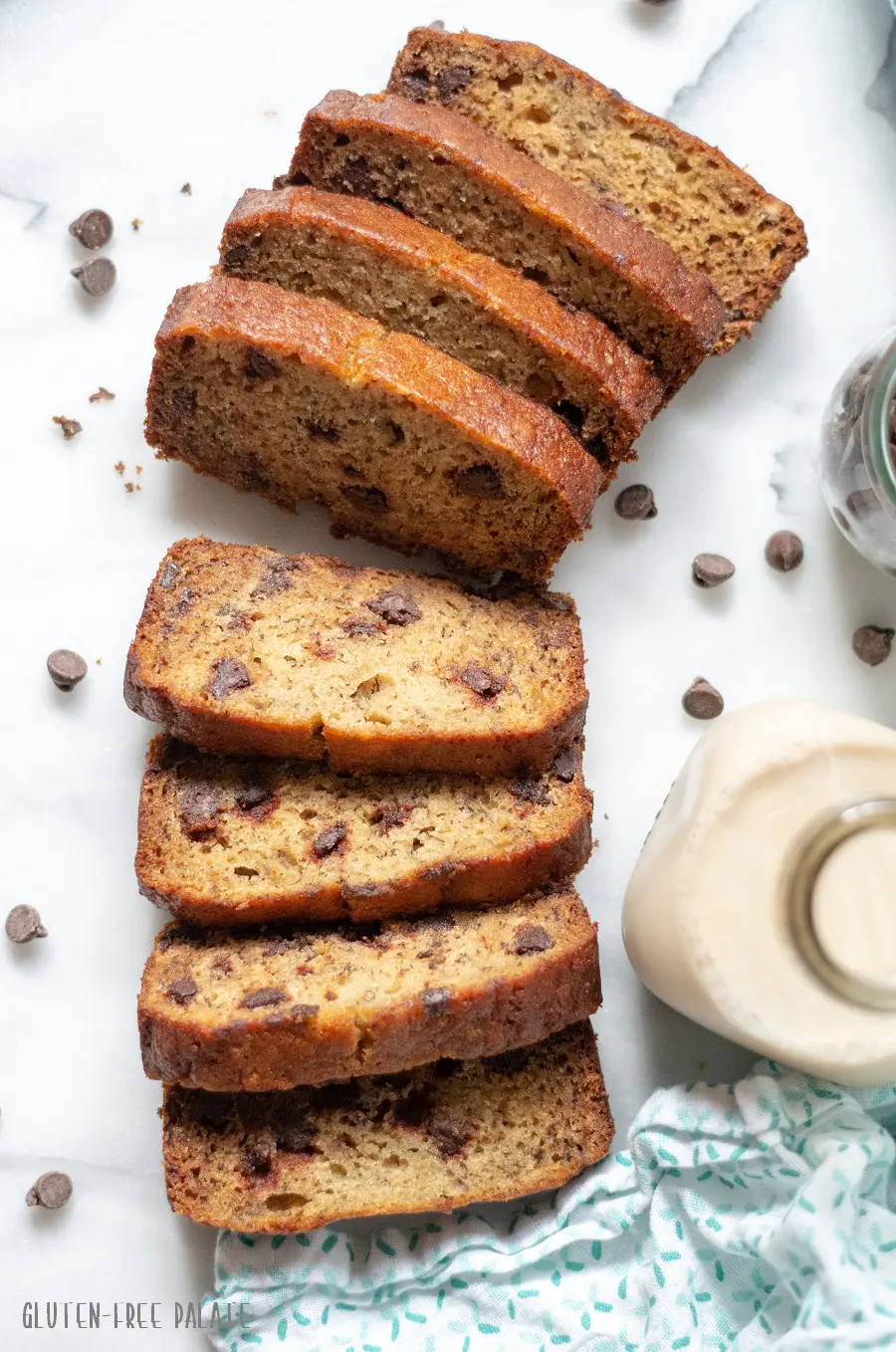slices of Gluten-Free Banana Bread with scattered chocolate chips and a jar of milk