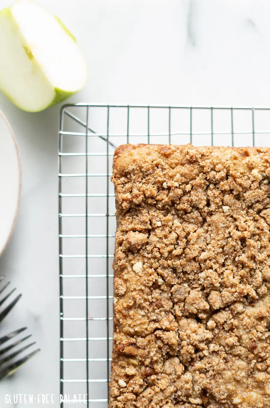 paleo apple cake on a wire rack with a slice of green apple