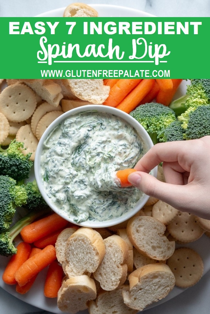 a hand dipping a corrot into a bowl of spinach dip with the words easy 7 ingredient spinach dip written in text at the top