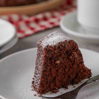 A slice of Gluten-free chocolate bundt cake on a white plate.
