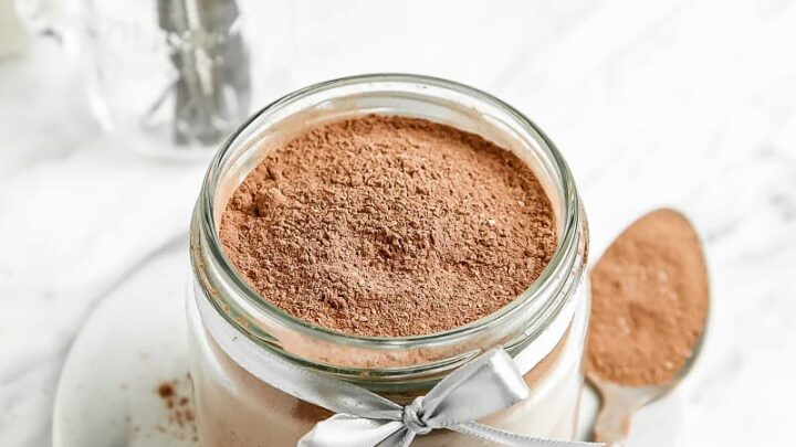 gluten free hot cocoa mix in a clear jar with a spoon