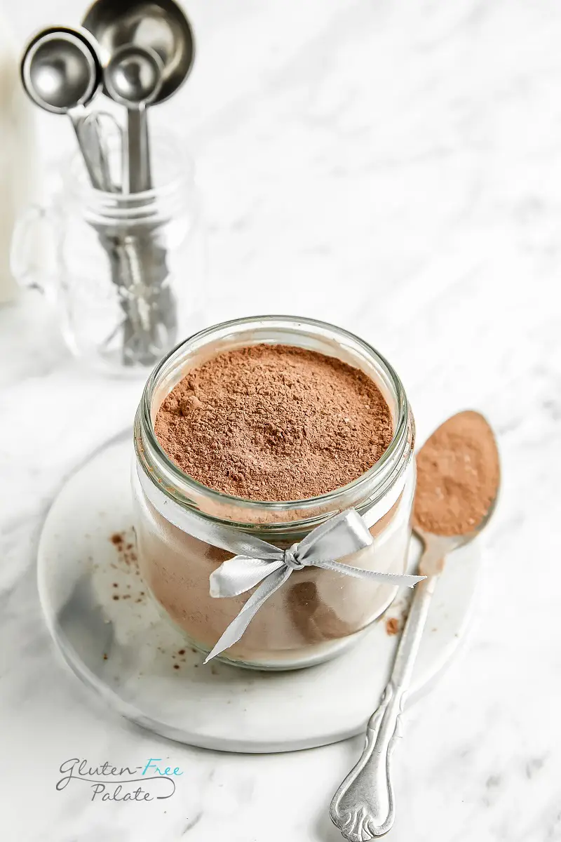 gluten free hot cocoa mix in a clear jar with a spoon