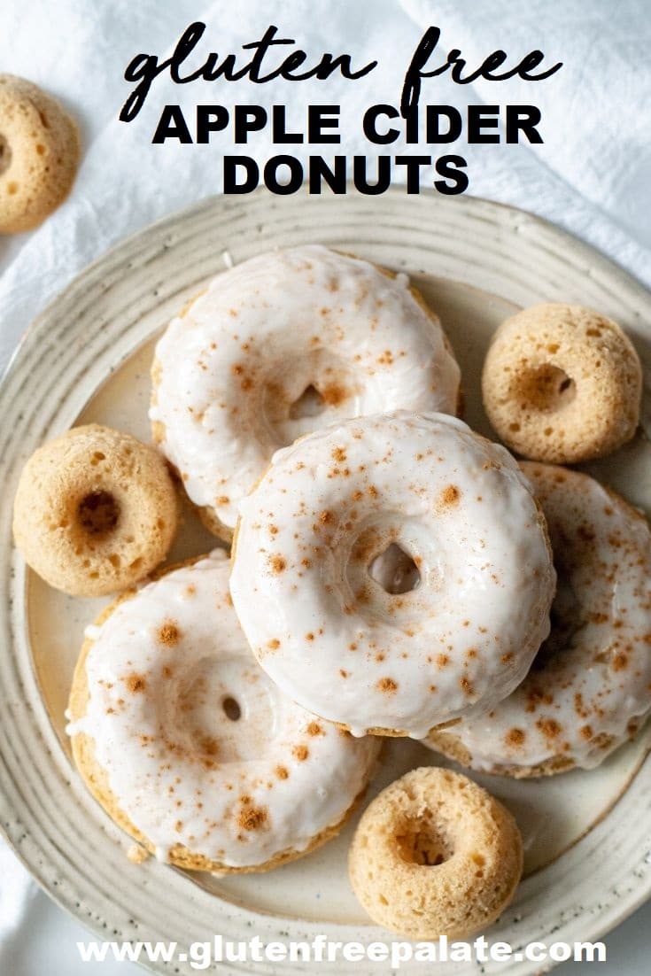 close up of gluten free apple cider donuts with white icing and cinnamon sprinkled on top on a cream colored plate with the words gluten free apple cider donuts in text at the top