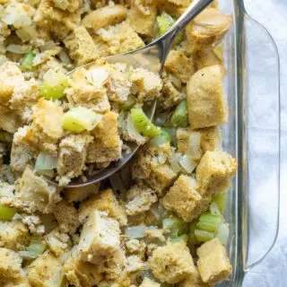 paleo stuffing in a glass pan with a serving spoon