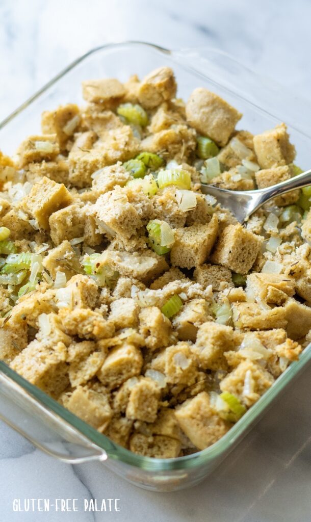 paleo stuffing in a glass pan with a serving spoon