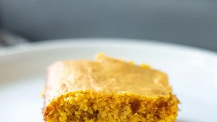 a slice of yellow paleo cornbread on a white plate