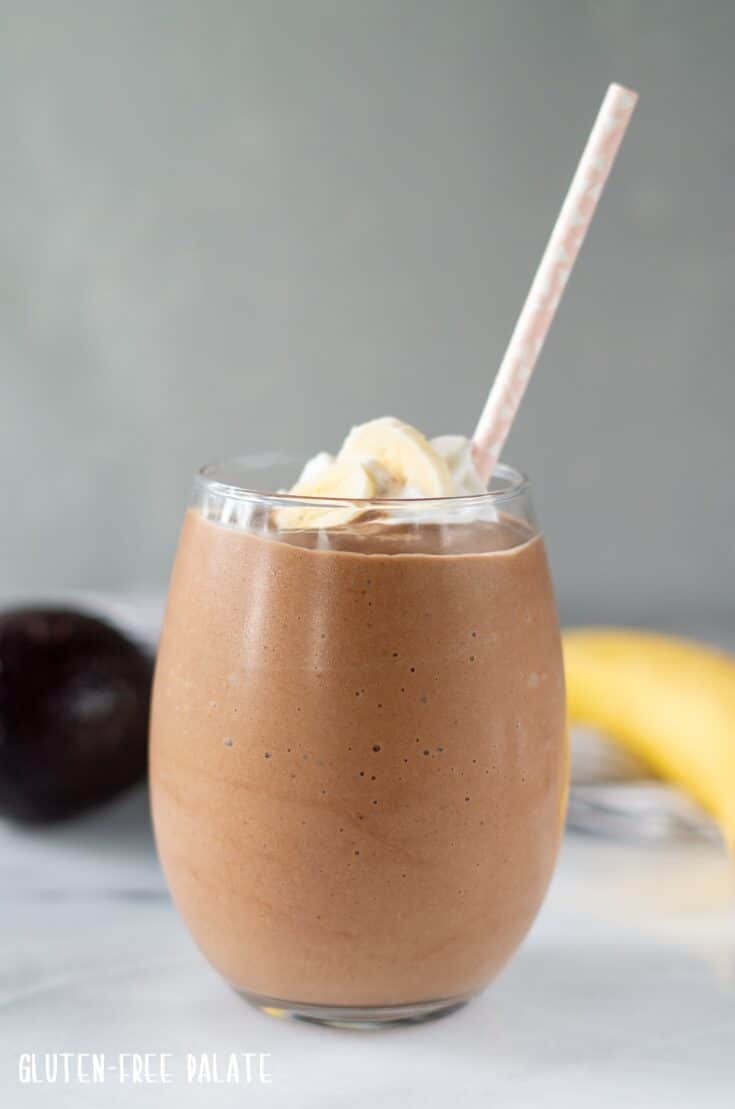 Chocolate Avocado Smoothie in a clear glass with a pink straw