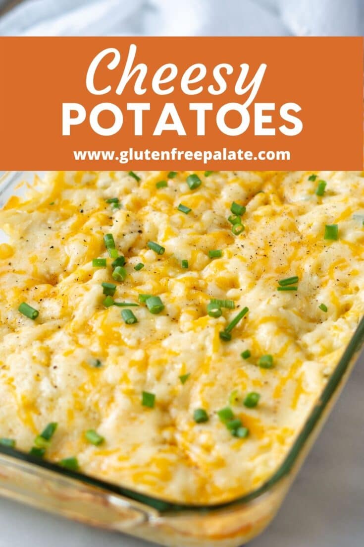 close up of cheesey potatoes in a glass baking dish with chopped green onion on top with the words cheesey potatoes on an orange box