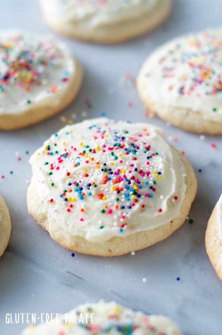 close up of a gluten Free Sugar Cookie with white froting and colored sprinkles
