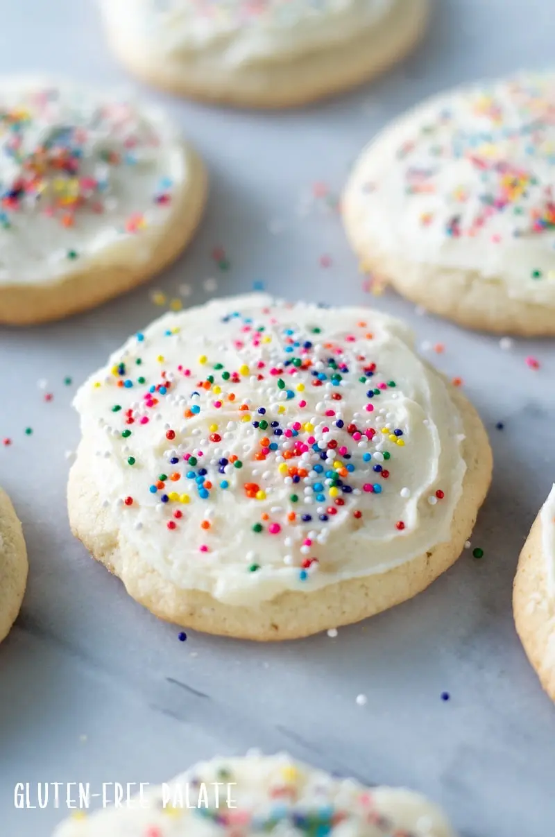 close up of a gluten-Free Sugar Cookie with white froting and colored sprinkles