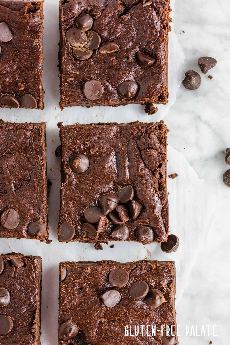 a close up of sliced flourless brownies topped with chocolate chips