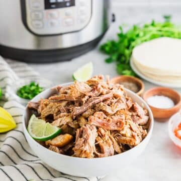 shredded carnitas in a white bowl