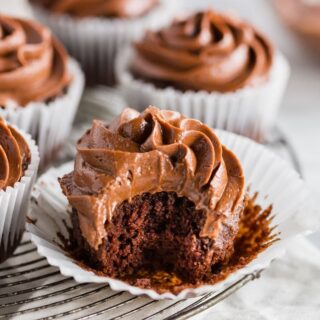 a paleo chocolate cupcake with chocolate frosting, with a bite taken out