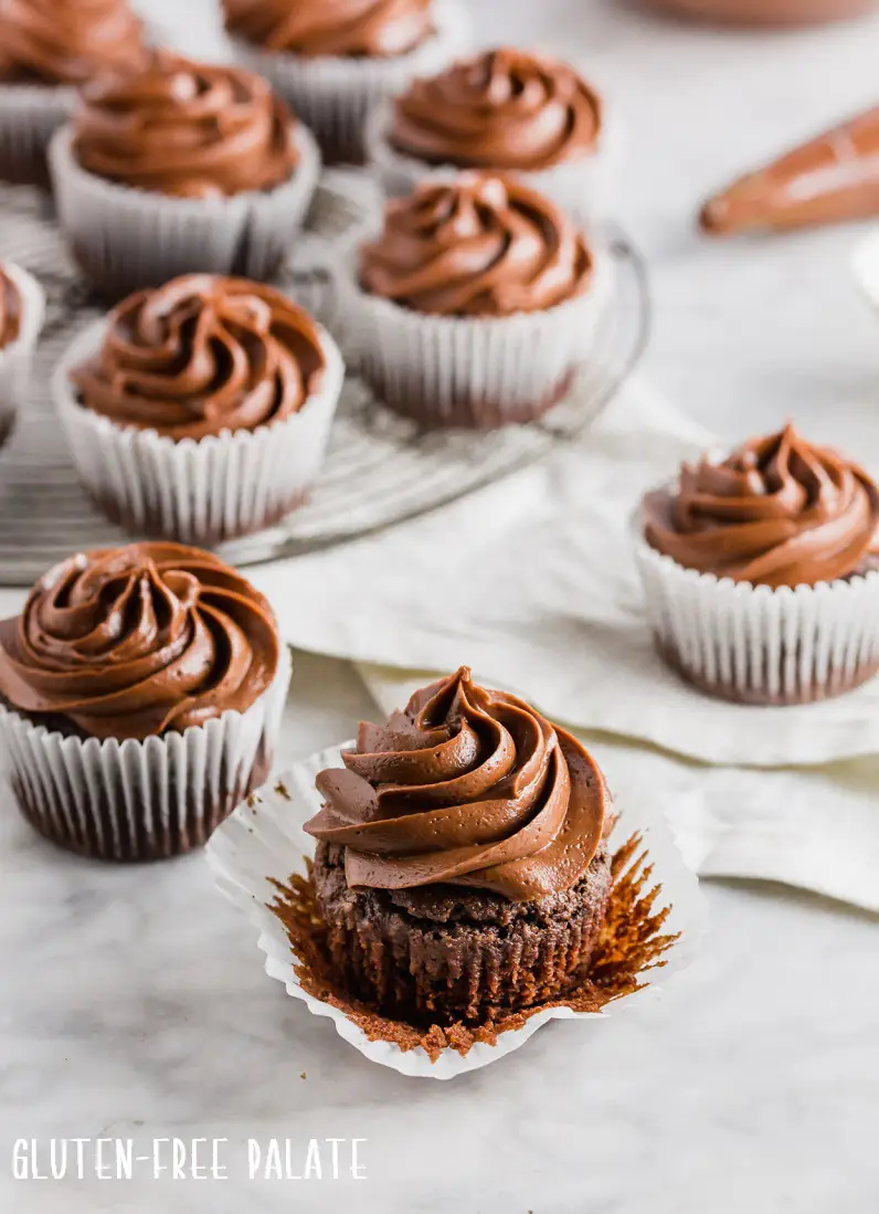 chocolate cupcakes in white paper liners topped with chocolate frosting