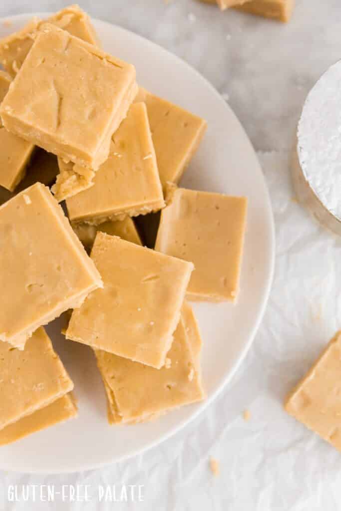 Top down view of gluten free peanut butter fudge pieces on a white plate ready to serve