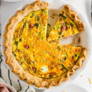 gluten-free quiche in a white pie pan with a slice out