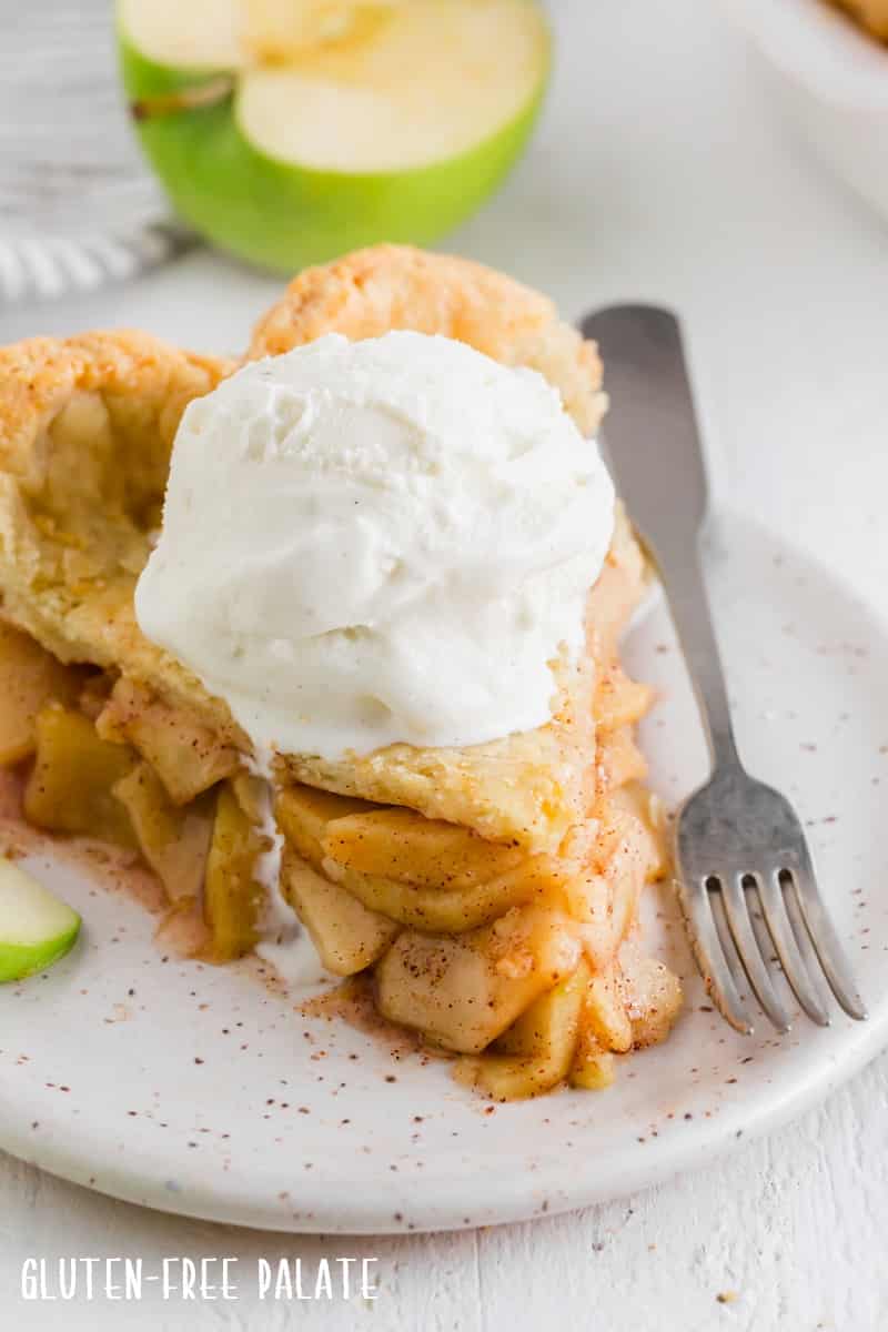 a close up of a slice of gluten-free apple pie with a scoop of ice cream