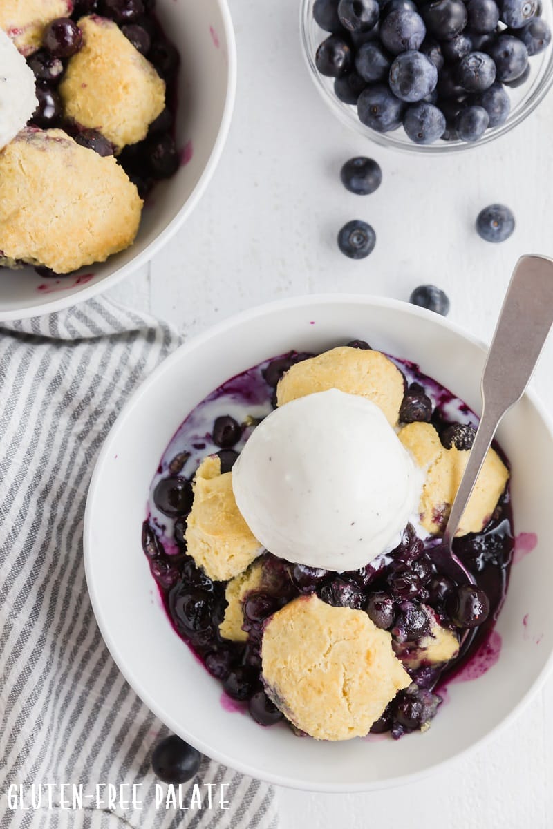 gluten free blueberry cobbler topped with a scoop of vanilla ice cream
