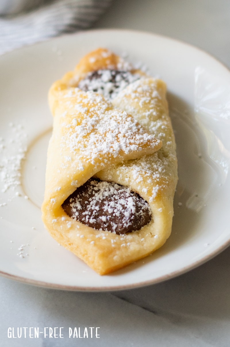 close up of gluten-free puff pastry filled with Nutella with powdered sugar on top.