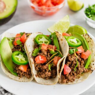 three gluten free tacos on a white plate
