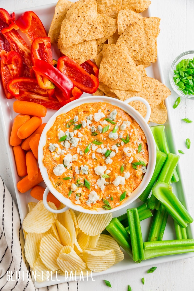 top down view of instant pot buffalo chicken dip in a white bowl with sliced veggies