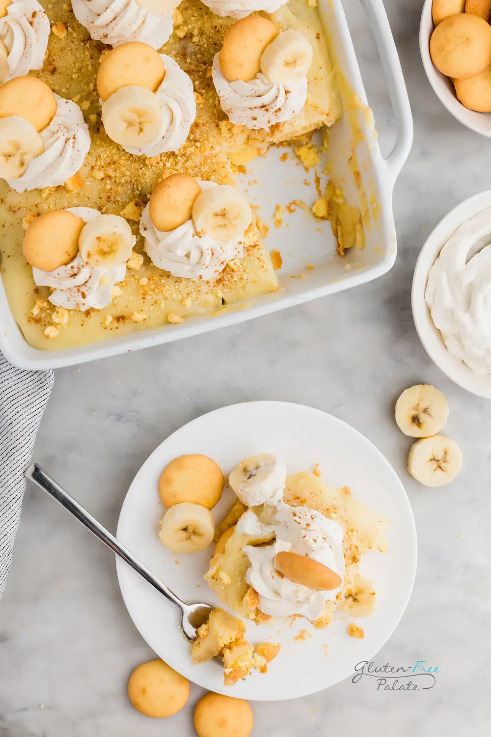 gluten free banana pudding on a white plate next to a pan of gluten free banana pudding