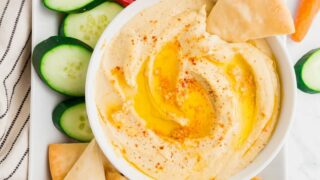 a bowl of gluten free hummus on a tray with vegggies