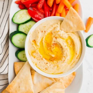 a bowl of gluten free hummus on a tray with vegggies