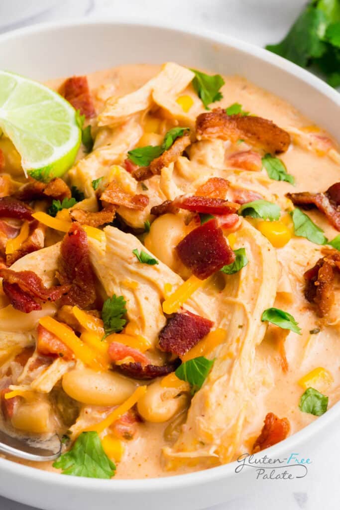 crack chicken chili in a white bowl with a lime wedge