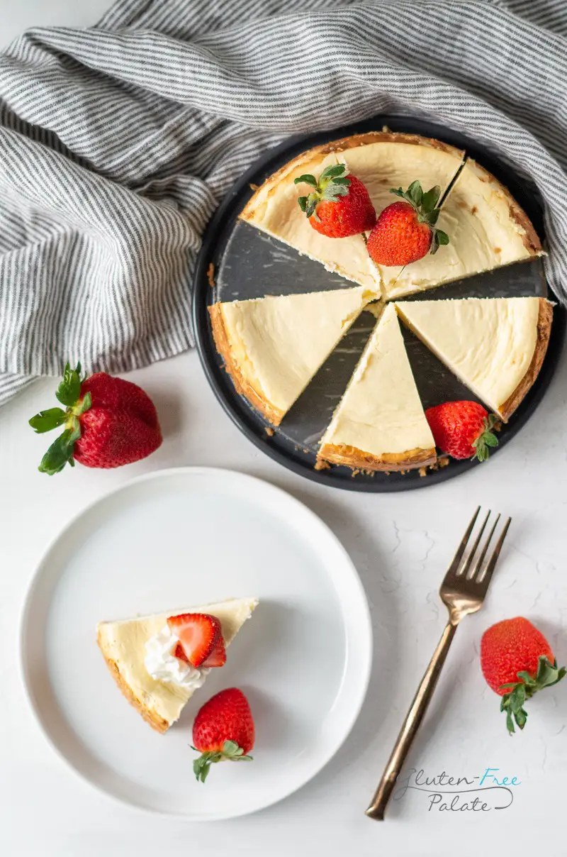 gluten-free cheesecake on a pan next to a plate with cheesecake