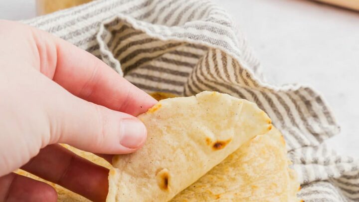 a hand folding up a gluten-free tortilla