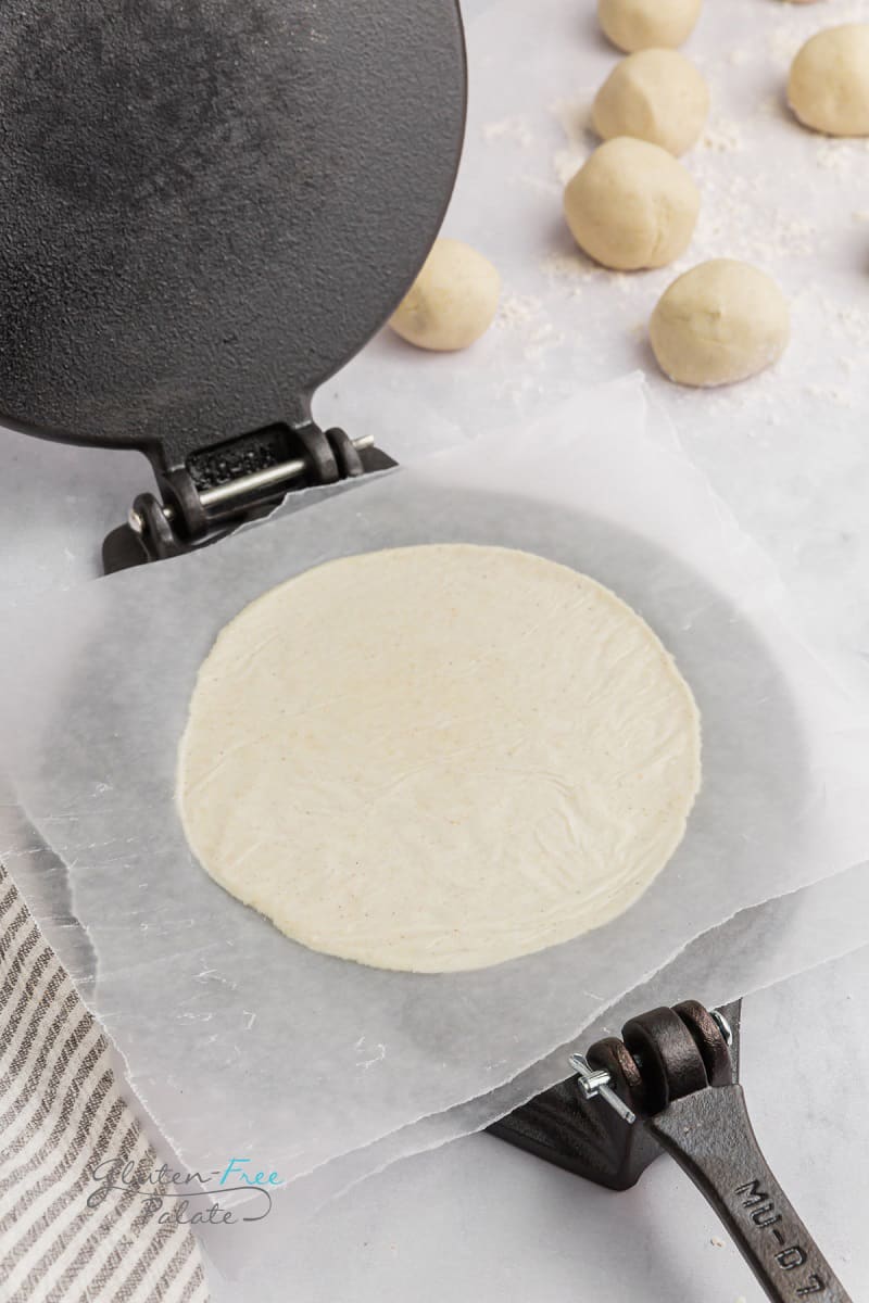 a tortilla press with a gluten free tortilla pressed out