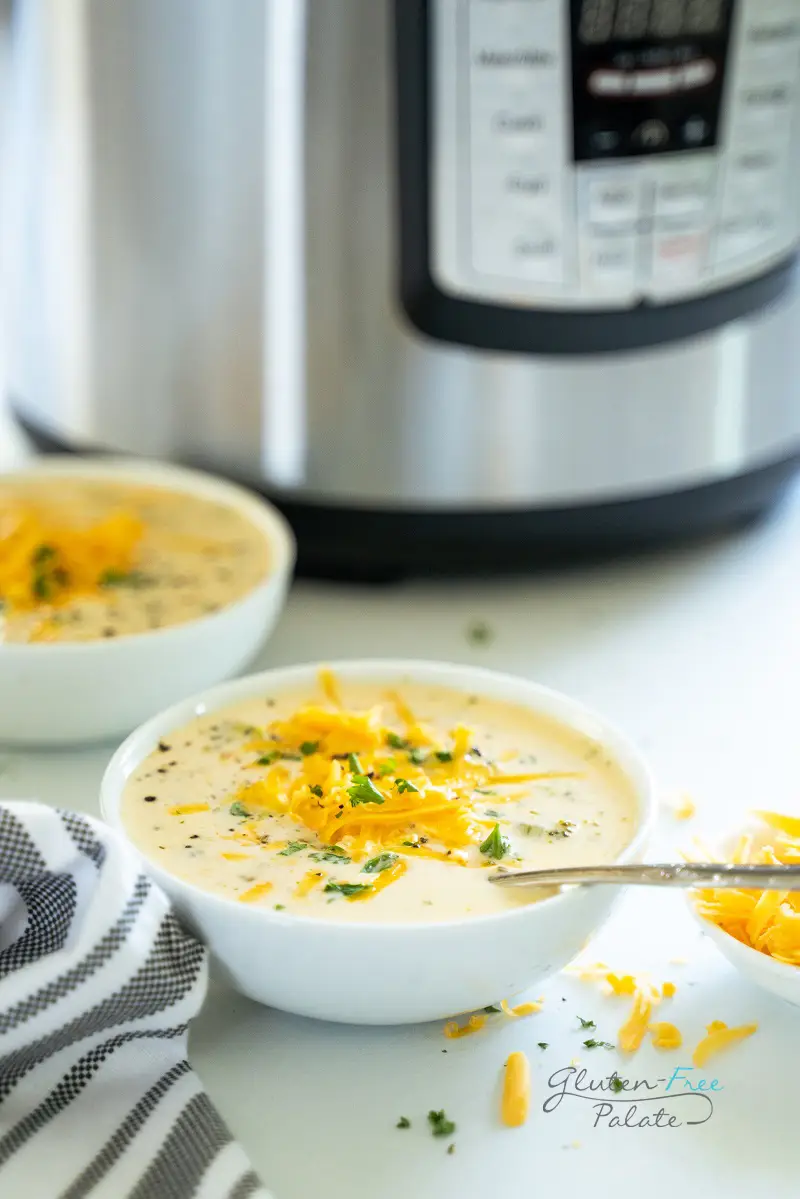 side view of instant pot broccoli cheese soup in a white bowl