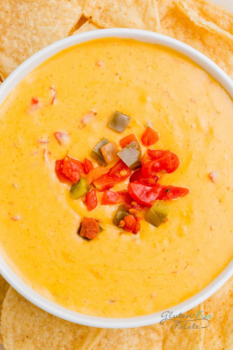 close up of smoked queso in a bowl with tomatoes on top