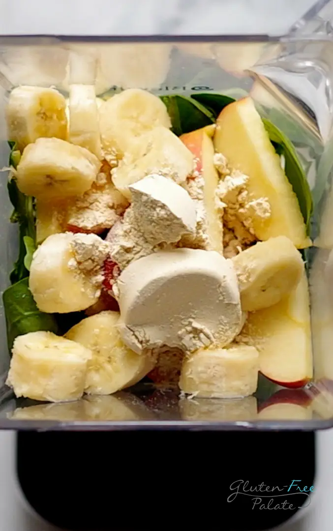 close up of ingredients in a apple spinach smoothie in a blender jar