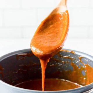 a wooden spoon with gluten free enchilada sauce