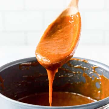 a wooden spoon with gluten-free enchilada sauce