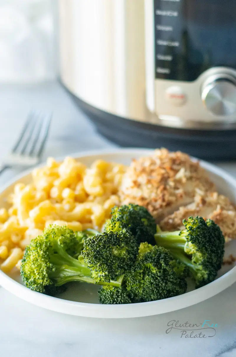 instant pot broccoli on a plate with chicken and noodles