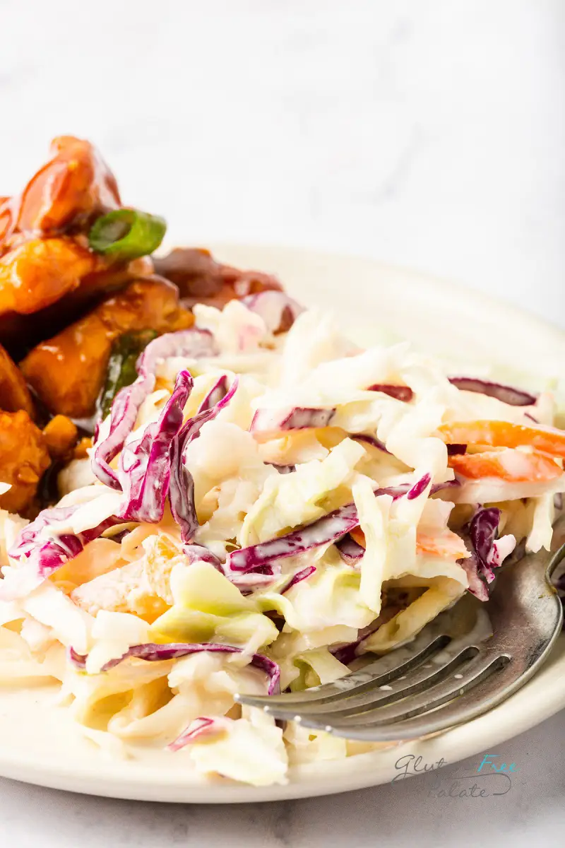 a dinner plate with coleslaw and bbq chicken.