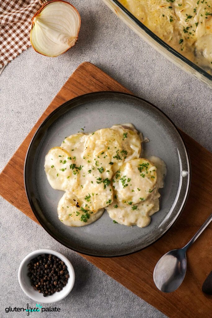 Overhead image of Gluten-Free Scalloped Potatoes on a grey plate with a spoon.