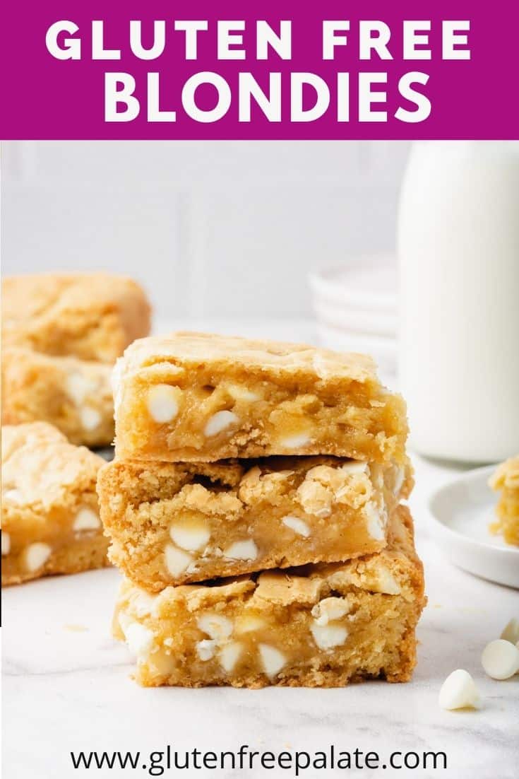 Three Gluten-Free Blondies filled with white chocolate chips and stacked on top of each other. In the background is a glass bottle of milk and more blondie squares.