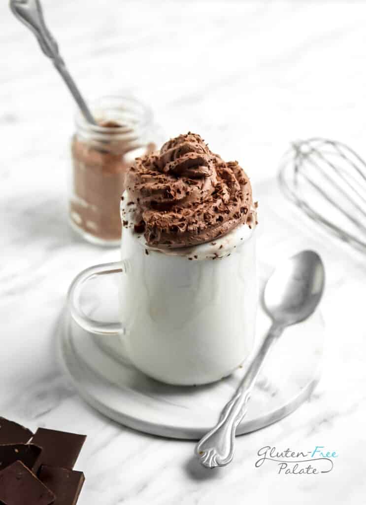 A glass mug of whipped cream topped with whipped chocolate.