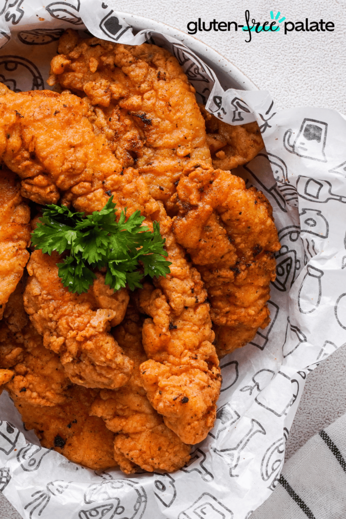 A basket of crispy chicken tenders made with only gluten-free ingredients.