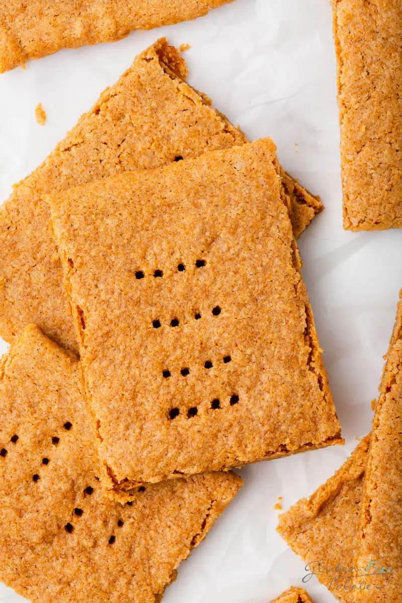 rustic looking homemade gluten-free graham crackers piled on a marble counter.